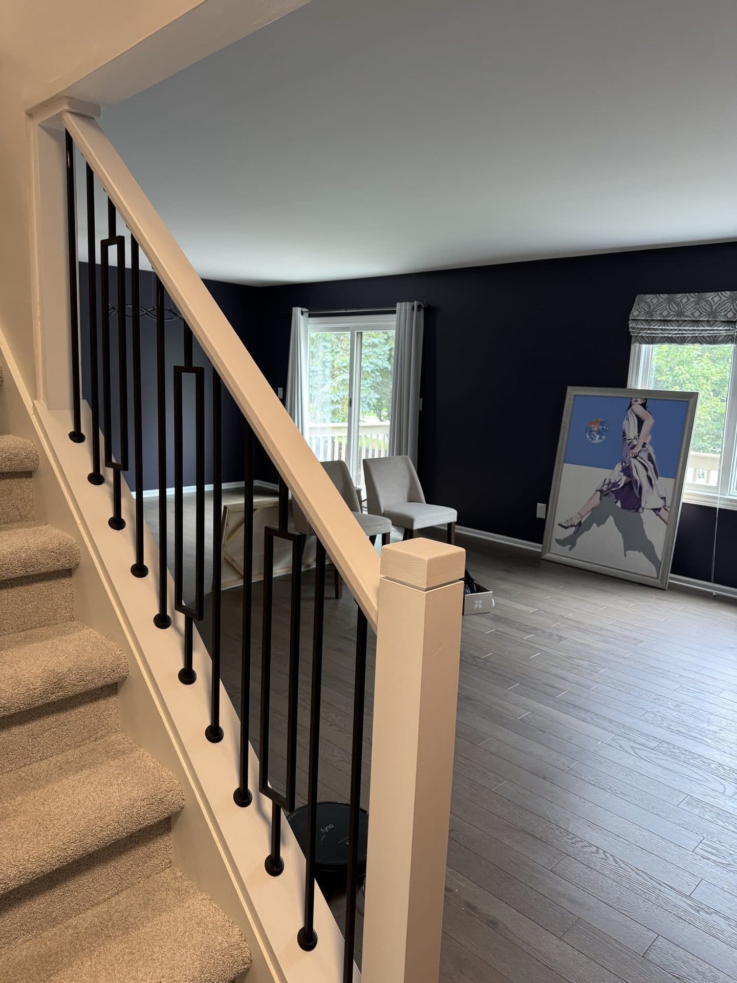 An upstairs landing overlooking the staircase, with a navy accent wall and white trim
