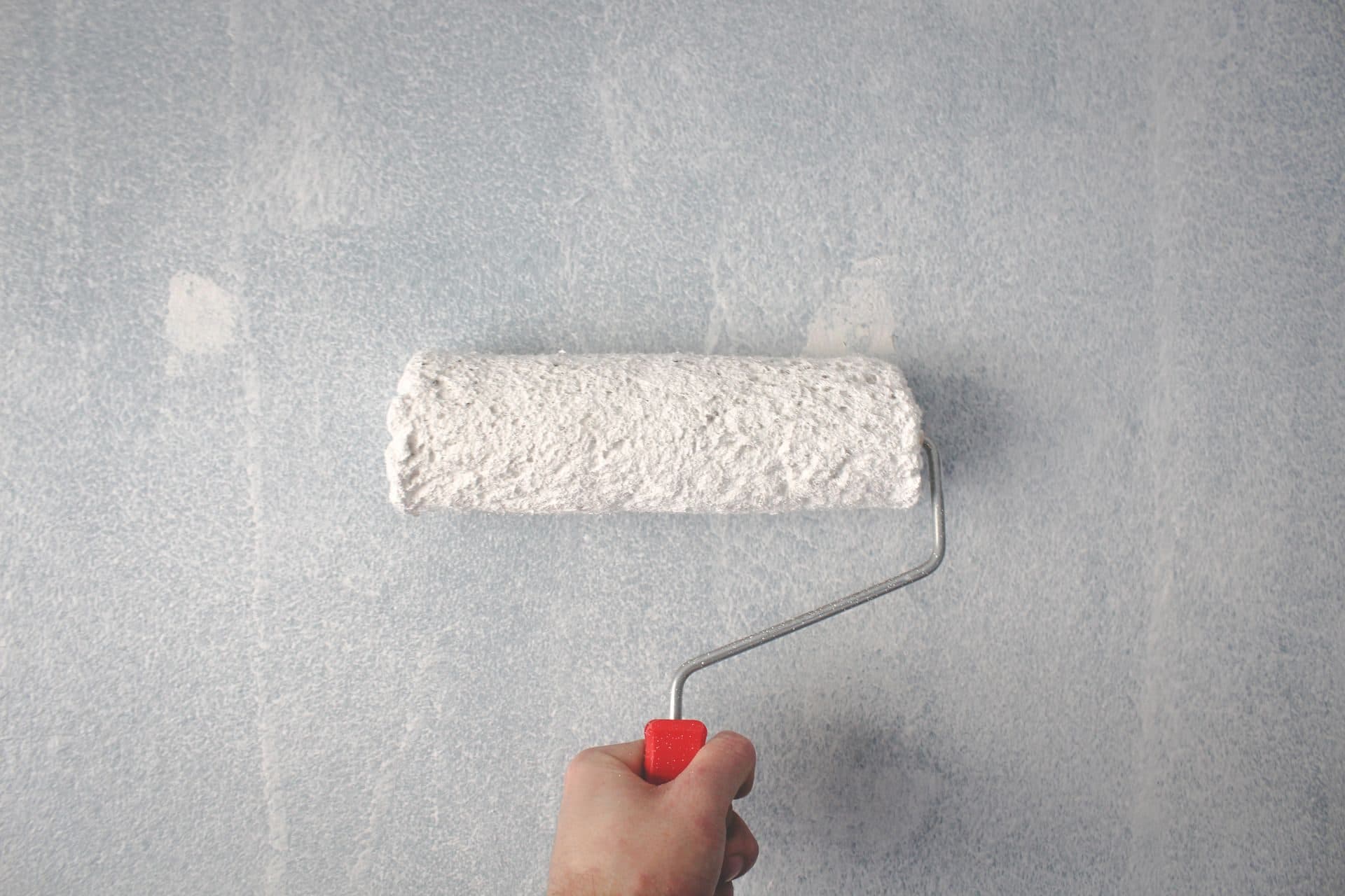 Close-up of a paint roller laying down a smooth, even coat