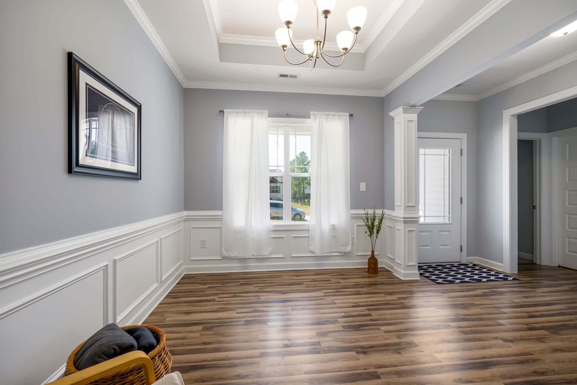A freshly painted living room with smooth neutral walls, crisp white trim, and a clean finish